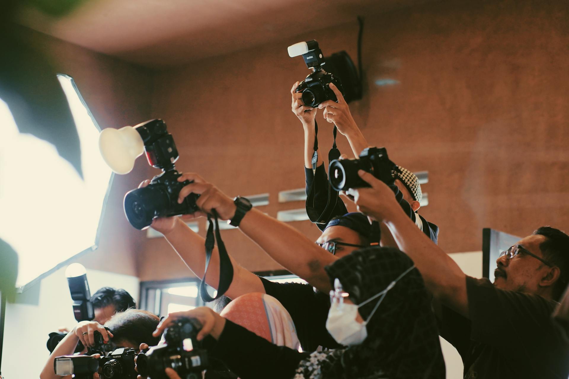 Press photographers raising cameras